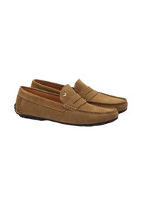Mocasines de ante marrón con un diseño cosido y un lado elástico. La suela exterior es de goma negra con un agarre texturizado para tracción.