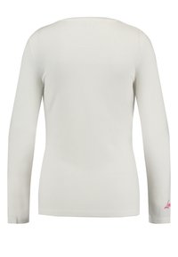 Camicia a maniche lunghe di colore avorio, realizzata in tessuto lavorato. Presenta un colletto arrotondato e un accento del logo rosa sulla manica inferiore.