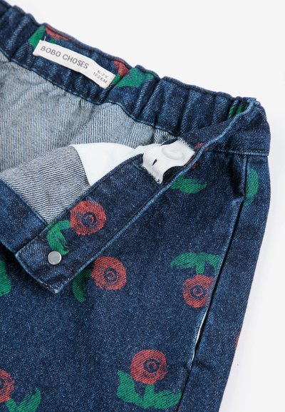 Pantalon enfant bleu foncé avec imprimé fleur rouge et feuille verte, taille élastique, patte à bouton réglable et étiquette indiquant la taille 6-7 ans.