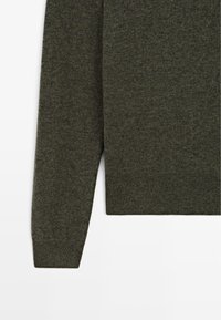 Maglione pullover verde scuro, realizzato in morbido tessuto a maglia. Presenta un collo rotondo e polsini a coste, con un design pulito e minimalista.