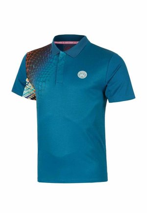 Polo à manches courtes bleu avec un col texturé, un motif en écailles multicolores sur l'épaule gauche, et un logo circulaire blanc sur la poitrine.