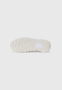 Semelle de sneaker blanche avec des motifs texturés et des rainures pour une meilleure adhérence, présentant un bord lisse et une légère courbure au niveau de la zone des orteils.