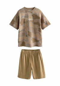 Koszulka typu T-shirt z krótkim rękawem w kamuflażowy wzór w odcieniach beżowym i brązowym, z okrągłym dekoltem; zestawiona z jednolitymi spodniami szortami w kolorze beżowym z elastycznym pasem dla spójnego wyglądu.