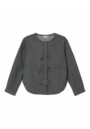 Blusa de manga larga con rayas verticales en blanco y negro, cuello redondo y tres pequeños lazos alineados en el centro delantero.