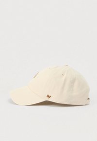 Μπεζ бейζμπολ καπέλο με καμπυλωτό γείσο, κεντημένο λογότυπο σε καφέ χρώμα, ρυθμιζόμενο λουράκι στο πίσω μέρος και απαλό βαμβακερό ύφασμα.