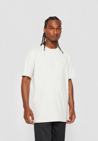 Lichtgrijze katoenen t-shirt met een ronde halslijn en korte mouwen, met een ontspannen pasvorm en minimale naden.