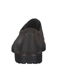Zapato de cuero marrón con puntera redondeada, textura suave, detalles cosidos en la parte superior y suela de goma negra texturizada.