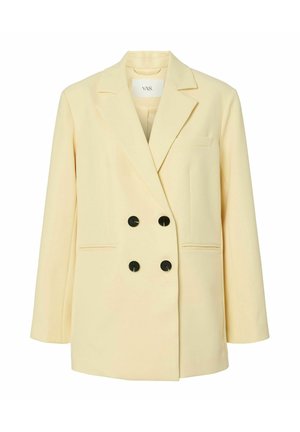 Blazer crema doppiopetto con rever a lancia, quattro bottoni neri, due tasche frontali e una tasca sul petto.