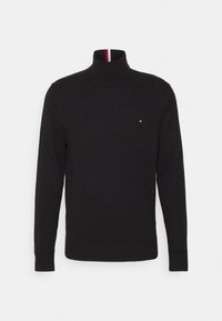 Czarny sweter typu golf w dzianinowym materiale. Posiada wysoki kołnierz oraz małe logo na piersi. Żebrowane mankiety i dół dodają tekstury.