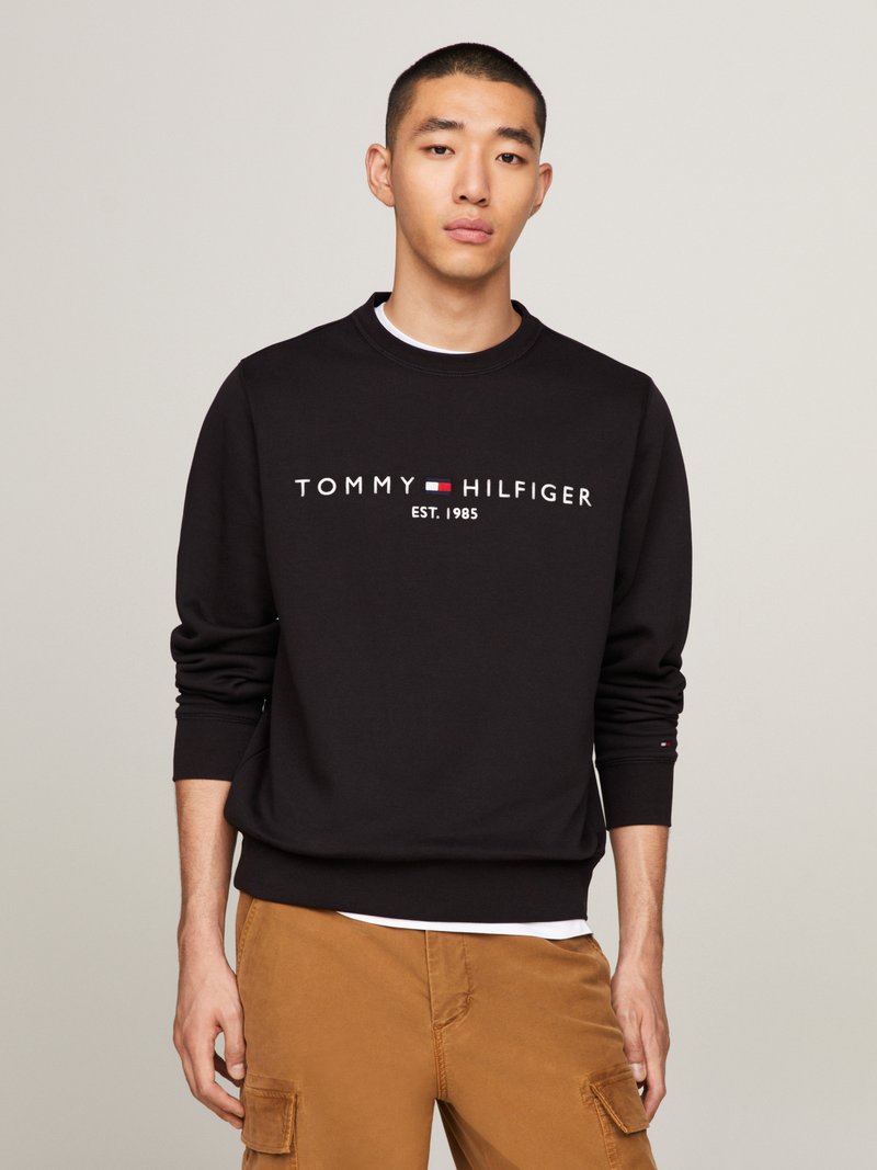 Schwarzer Baumwollpullover mit dem Logo "TOMMY HILFIGER" in Rot und Weiß. Mit gerippten Bündchen und Rundhalsausschnitt.