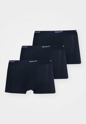 Trzy pary ciemnoniebieskich bokserków wykonanych z bawełny, z elastycznym pasem w których widnieje nazwa marki "GANT" w białym kolorze.