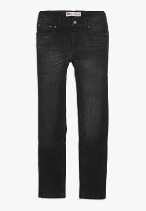 Jean noir slim tapered avec cinq poches et fermeture par bouton, montrant une décoloration subtile sur la zone avant de la cuisse.