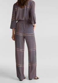 Tryckt byxdress i mörk marinblå med geometriska mönster, med vida ben, 3/4 ärmar, resårmidja och kontrasterande randiga detaljer.