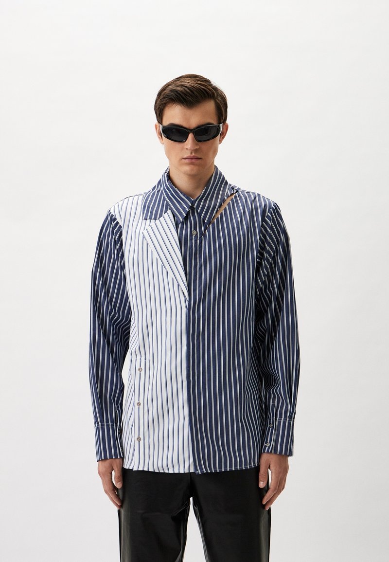 Gestreiftes Hemd mit kontrastierenden blauen und weißen Paneelen, mit einem Ausschnitt am Kragen, Knöpfen vorne und langen Ärmeln.