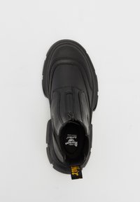 Černé kožené kotníkové boty s texturovaným svrškem, elastickými bočními panely a silnou gumovou podrážkou. Disponují poutkem s žlutým nápisem.