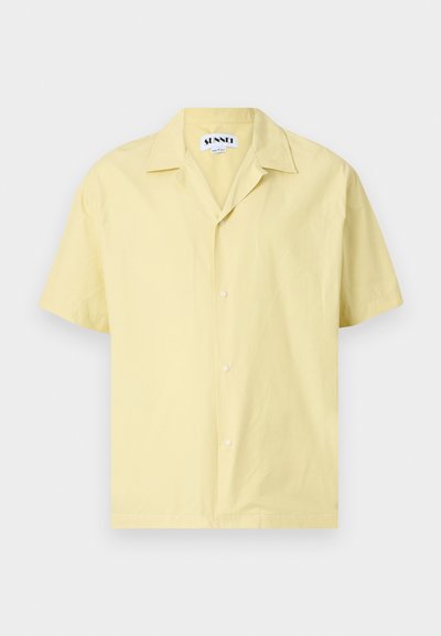 Camisa amarilla de manga corta hecha de algodón. Presenta un cuello de tipo camp, botones en la parte delantera y una forma relajada. Textura suave y color sólido.