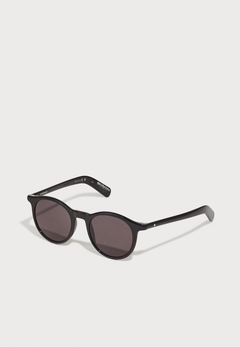 Black round sunglasses with dark lenses, plastic frame, slightly textured arms, and subtle metallic accents on the hinges.