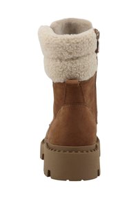 Brune ruskind støvle med en cremefarvet faux fur krave, lynlås på siden og en tyk, rillede gummisål. Bagudsigt der viser den afrundede top.