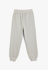 Pantalones de chándal grises, hechos de una tela suave, presentan una cintura elástica, un frente con pliegues y puños ajustados. No tienen bolsillos.