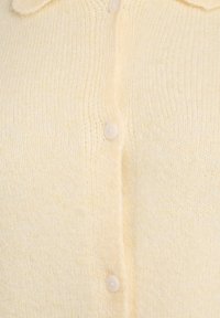Yellow knitted cardigan with a soft texture, featuring a classic collar and five matching buttons down the front.