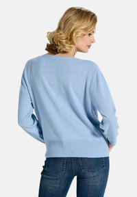Hellblaues Strickpullover mit lockerer Passform, weitem Ausschnitt und Rippbündchen. Lange Ärmel mit weicher Textur, entworfen für Komfort.