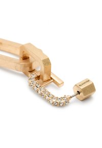 Accessorio in metallo dorato con design a catena, caratterizzato da strass trasparenti e un dettaglio di chiusura esagonale. Texture liscia e finitura lucida.