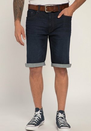 Shorts en denim bleu foncé avec des revers, dotés de poches avant, d'une ceinture marron, et associés à des baskets montantes bleu marine.