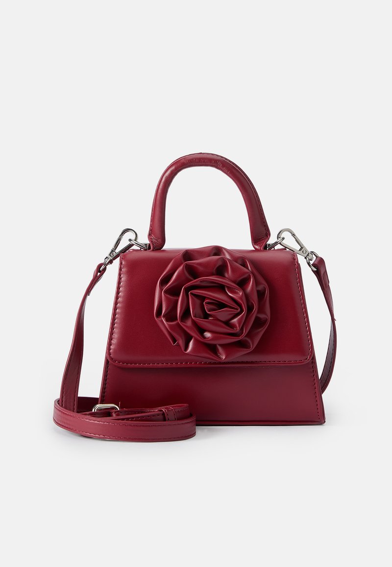 Borsa in pelle rossa con forma strutturata, caratterizzata da un grande fiore in rosa sul fronte, manico corto e una tracolla rimovibile.