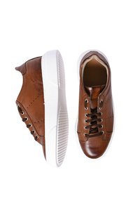 Sneaker in pelle marrone con suole in gomma bianca, caratterizzate da punta arrotondata, lacci davanti e dettagli di cucitura lungo i lati.