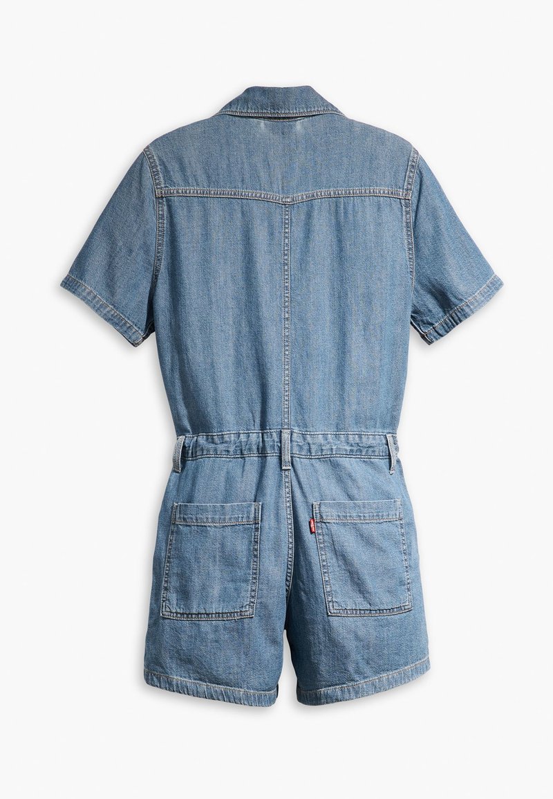 Une combinaison en denim à short présente un col, des manches courtes, une taille élastique et deux grandes poches arrière. Couleur bleu clair avec des détails cousus.