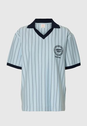 helehall sinise lühikeste varrukatega särgiga, millel on nõrgad mustad vertikaalsed triibud, must krae ja varrukaääred ning rinnal ümmargune "Amour Hotellid" logo.