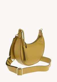 Sac à épaule en cuir jaune moutarde avec une forme arrondie, quincaillerie dorée et un détail à frange ; il comporte une bandoulière réglable.