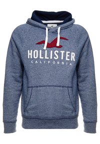 Modrá mikina s kapucí Hollister s bílými šňůrkami, přední kapsou a červeným logem racka nad bílým textem "Hollister California".