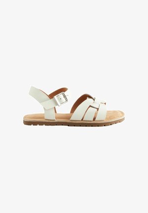 Witte lederen sandalen met een platte zool, voorzien van een gespband, een gekruist teenontwerp en een cognackleurig gevoerd voetbed.