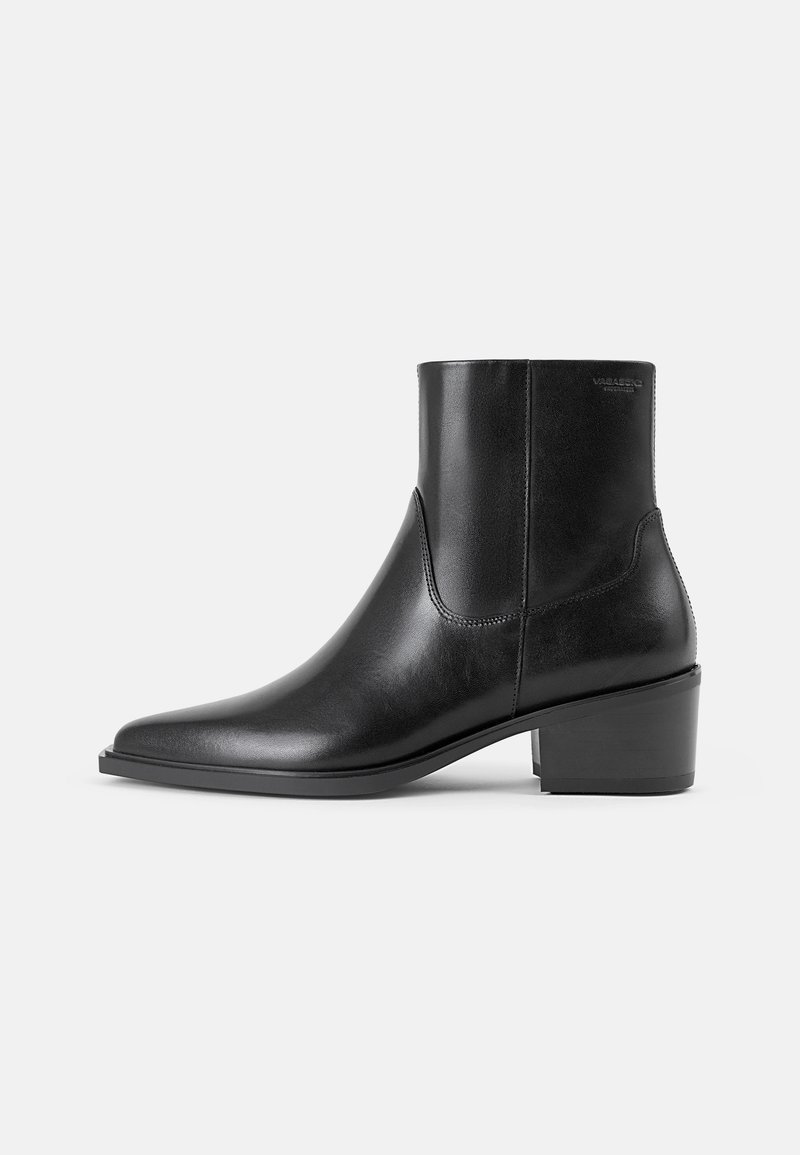 Bottines en cuir noir avec un bout pointu et un petit talon. Texture lisse, couture minimaliste et marquage à l'arrière.
