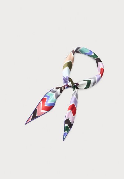 Foulard en soie avec motif chevron multicolore noué avec un nœud lâche sur un fond clair uni.