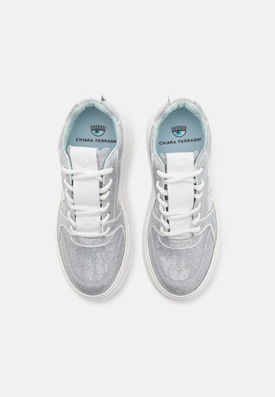 Baskets argentées pailletées avec des lacets blancs, une languette rembourrée et un intérieur bleu clair. Le nom de la marque "Chiara Ferragni" est visible à l'intérieur.