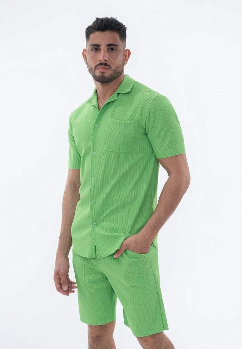 Chemise verte à manches courtes avec un motif côtelé et une poche, assortie à un short. Tissu léger et détails de fermeture à boutons.