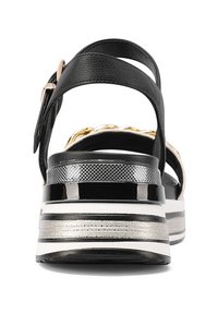 Sandali platform bianchi e neri con punta tondeggiante, caratterizzati da una elegante fascia nera e un dettaglio in catena metallica dorata sul retro.