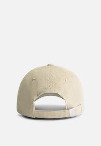 Casquette de baseball en corduroy beige avec une visière incurvée, une surface texturée, une sangle arrière pour ajustement, et un petit détail de logo sur la sangle.