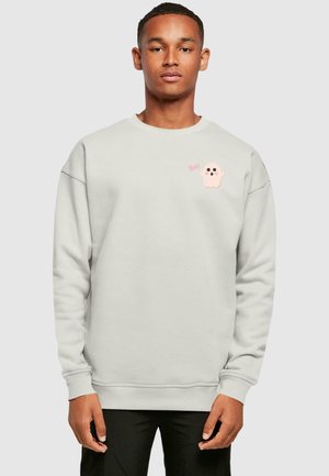 Hele hall sweatshirt pehmest kangast, millel on vasakul rinnal roosa kummitus ja tekst "Boo!". Ribitud varrukad ja äär.