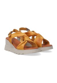 Yellow leather wedge sandals with twisted straps, padded footbed, and a white textured platform sole. Adjustable ankle strap with metal buckle.