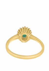 Zlatý prsteň s textúrovaným motívom pripomínajúcim mušľu, v strede so zeleným kameňom. Hladký pás a detailné vypracovanie zvýrazňujú jeho dizajn.