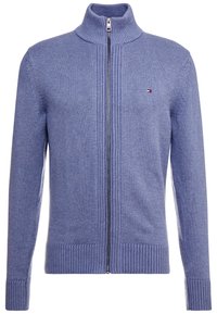 Blå stickad zip-up tröja med hög krage, ribbade muddar och nederkant, försett med en logotyp på vänster bröst. Slät textur.