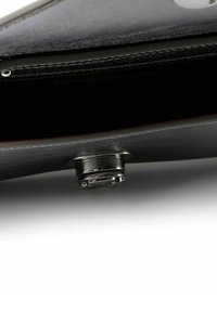 Interno di un portafoglio in pelle nera con chiusura a bottone a pressione in argento e cuciture visibili lungo il bordo. Presenta una fodera testurizzata.