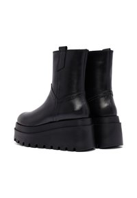 Czarne skórzane botki za kostkę z masywną platformą, gładka tekstura, minimalne przeszycia i boczne pętle do łatwego zakładania.