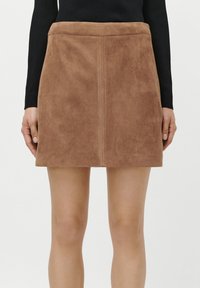 Fustă mini din suede maro, cu o croială dreaptă, talie plată și detalii cu cusătură frontală. Textură netedă și design simplu, elegant.