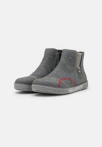 Bottines en daim gris avec des panneaux latéraux élastiques, des coutures rouge contrastantes et une semelle en caoutchouc texturée. Design épuré avec un matériel minimal.