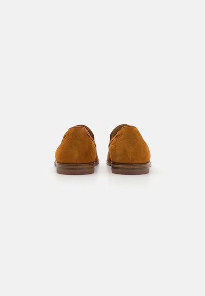 Brown suede shoes with a rounded toe, low heel, and contrasting light brown sole. Features perforated detailing along the upper sides.
