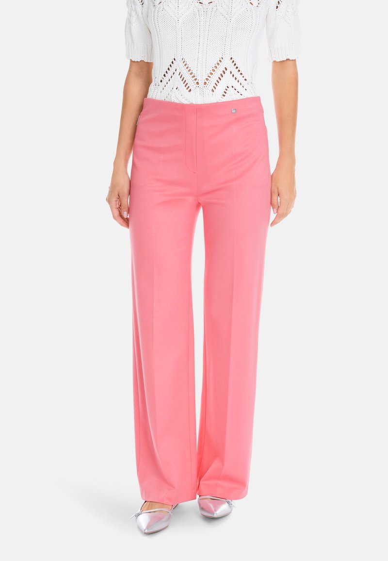 Pink wide-leg trousers made of soft fabric, featuring a flat front with pockets and subtle stitching details. Paired with silver shoes.